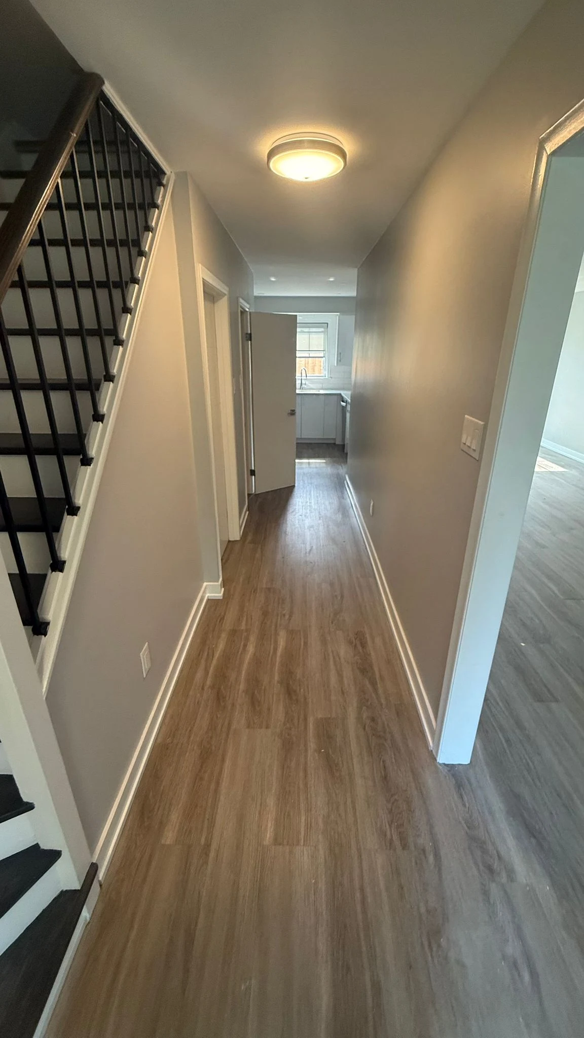 MIRG whole-home renovation showing staircase, hallway, kitchen and living area